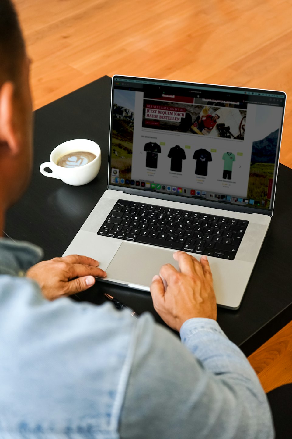 Persoon die online kleding koopt op een laptop.