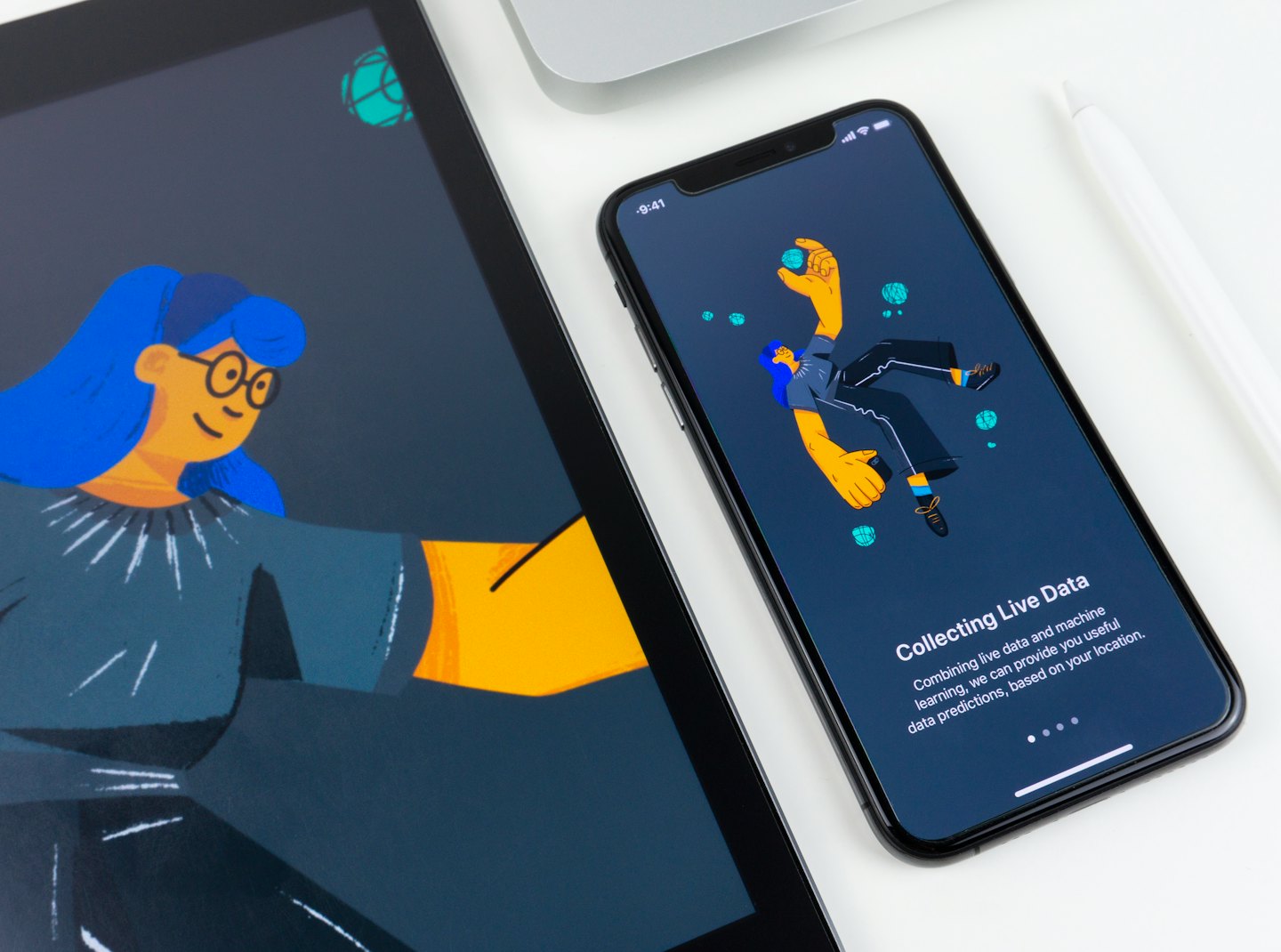 Tablet en smartphone met kleurrijke illustraties op een wit bureau.